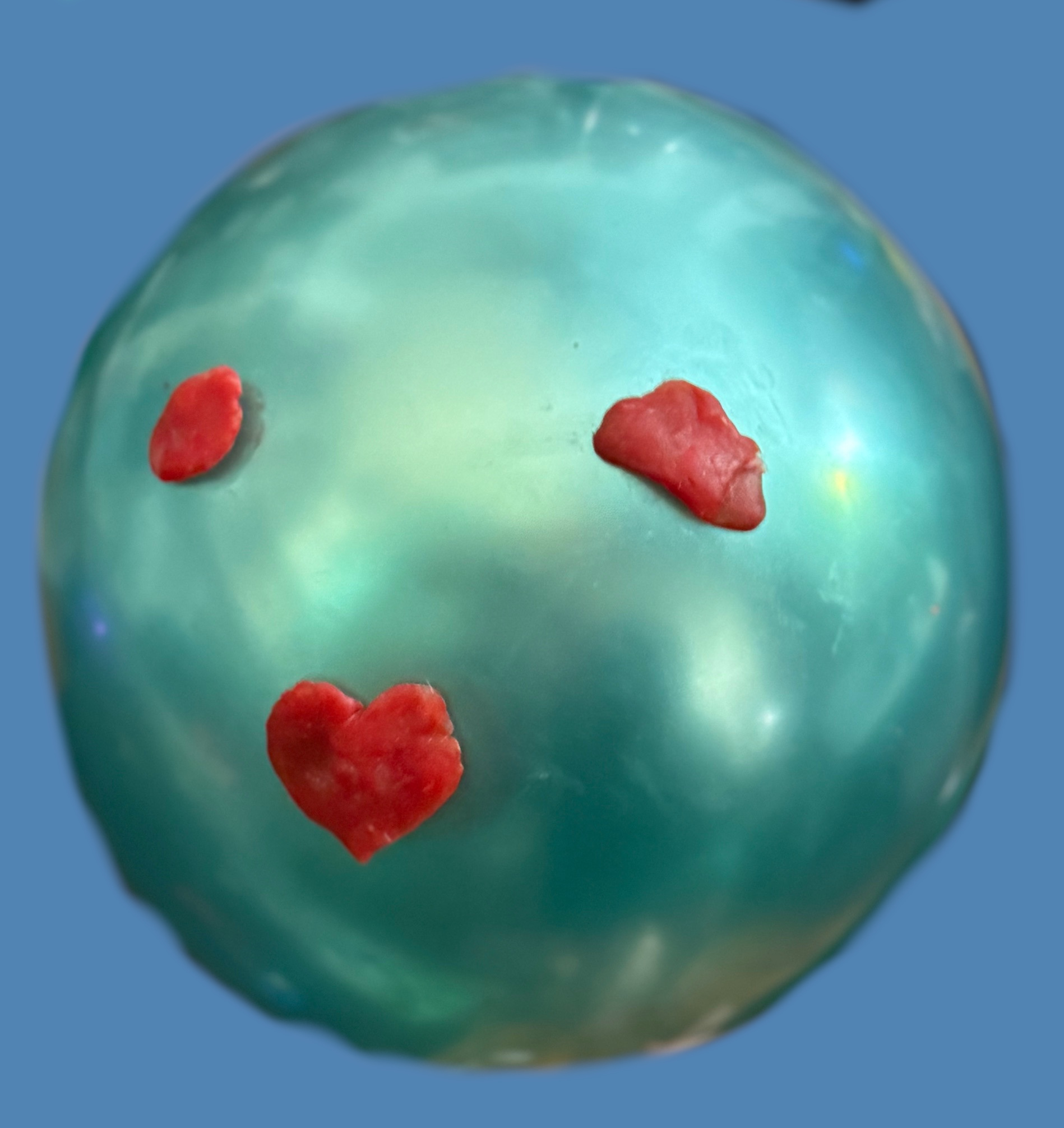 green balloon with red babybel cheese wax used to make a face